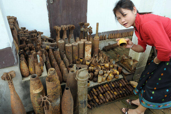 An employee of the Tourism Department of Xiengkhoang province shows off different kinds of US shells and bombs on display in the town of Phousavanh on April 03, 2008. 
