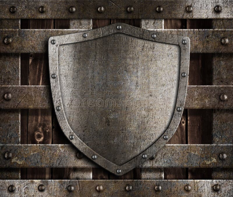Aged metal shield on wooden medieval gates stock photo