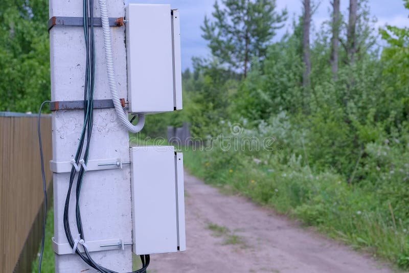 Electric shield on a street pole in the private sector, closeup view. Electric pole on a country road in the village near the fence. Modern equipment for stock images
