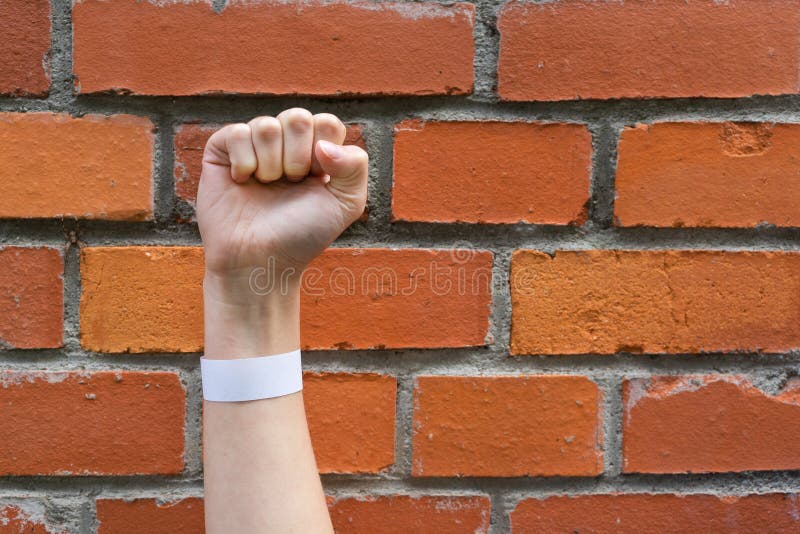 Hand clenched into a fist on a background of a brick wall. A sign of perseverance and resistance.  royalty free stock photos