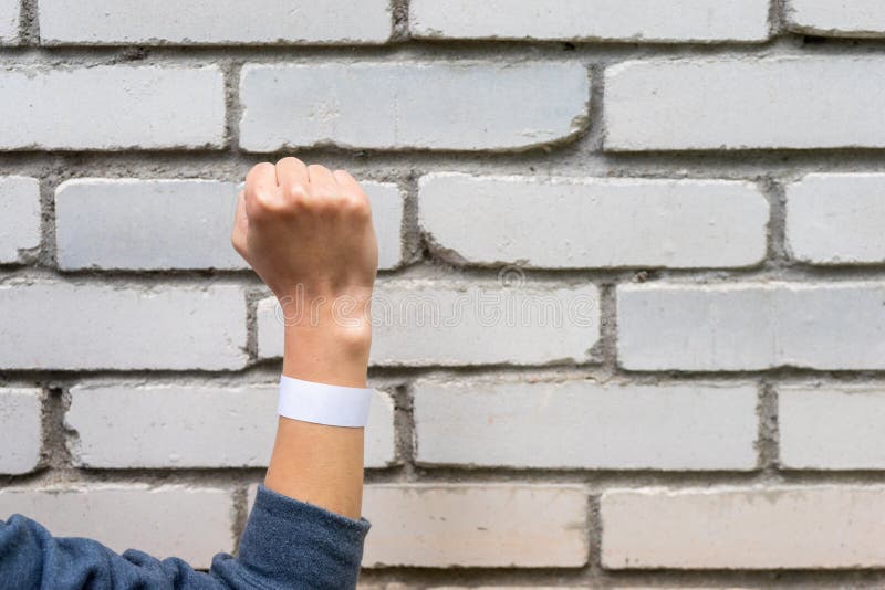 Hand clenched into a fist on a background of a brick wall. A sign of perseverance and resistance.  stock photography