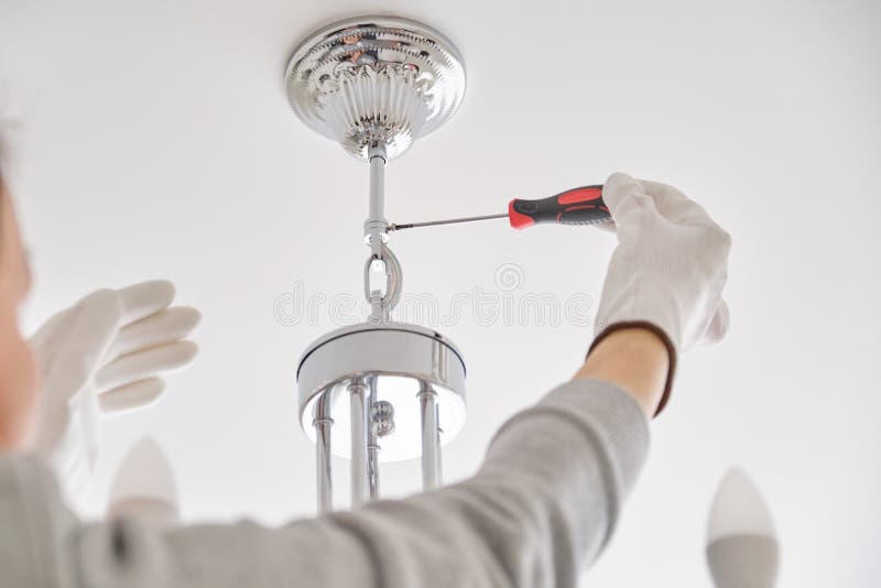 Installation ceiling lamp, hands of electrician fixing chandelier. With use of professional tools stock photos