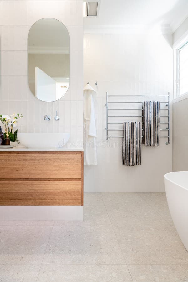 Luxury domestic bathroom shower and vanity with oak dresser drawers, white colour scheme. And bright lighting royalty free stock photography