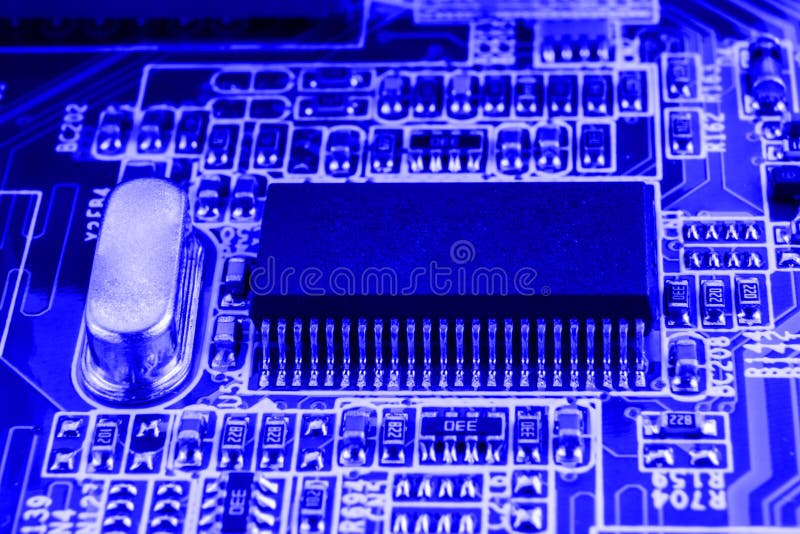 Microchip and quartz on the motherboard of a modern computer blue background close macro royalty free stock images