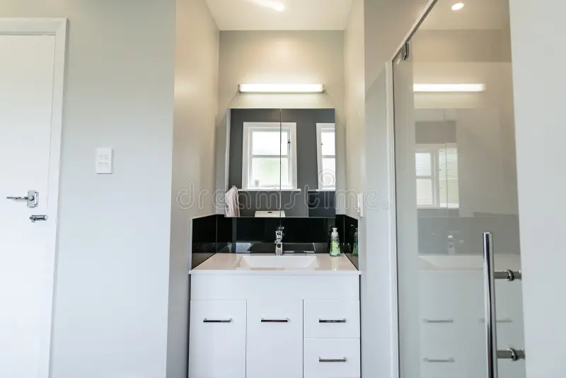 Modern White Apartment Bathroom. Small city apartment interior with white basin, sink shower and lighting stock photography