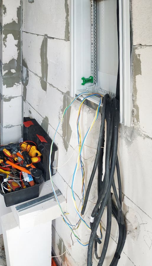 A new electric shield is installed on the wall of the newly built house, cables and tools are visible. 2019 royalty free stock image