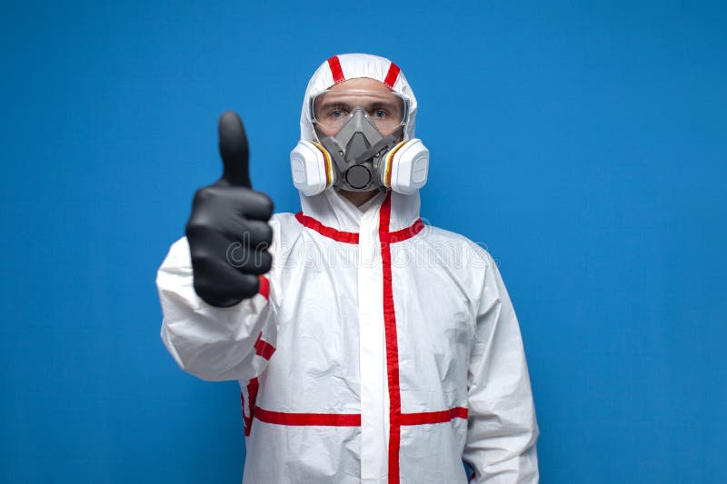 Resistance to coronavirus. disinfection worker in protective equipment and respirator shows like sign, virologist on. Blue isolated background stock photos