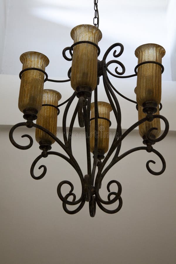 Wrought iron chandelier. A vintage wrought iron chandelier hanging from the ceiling royalty free stock image