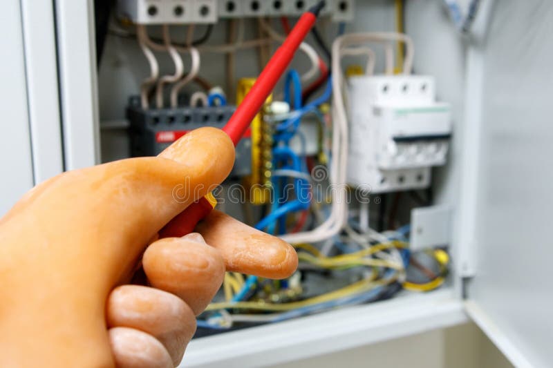 Work under tension, rubber glove is put on the hand in the electric shield, electric machines and electric shield. Safety when working with electricity royalty free stock photography